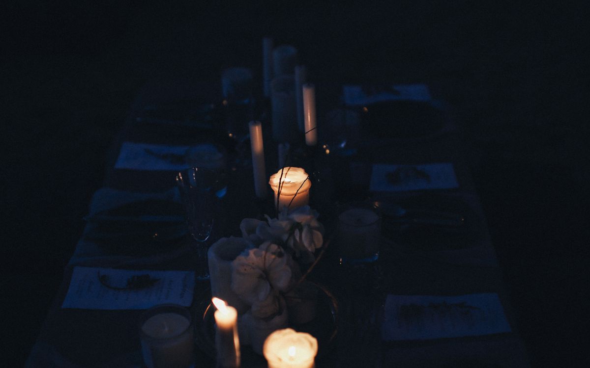A candlelit dinner table in the courtyard at night